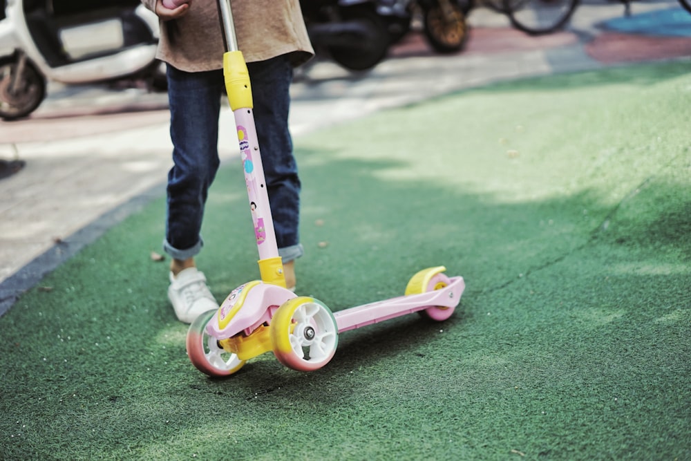 pink and white kick scooter on green grass field during daytime