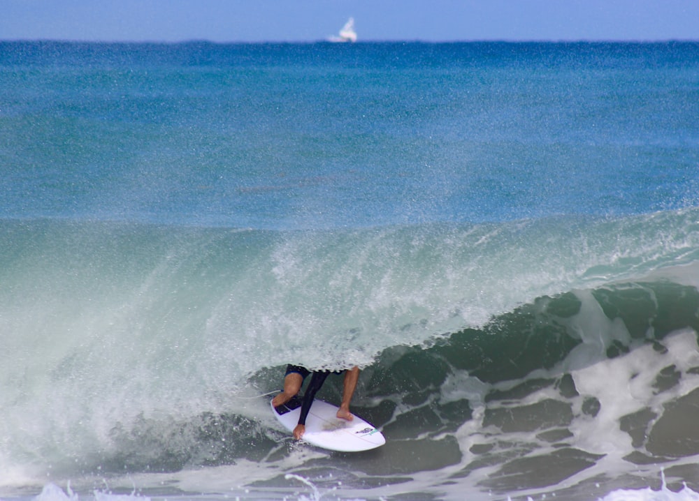 man in black wet suit surfing on sea waves during daytime