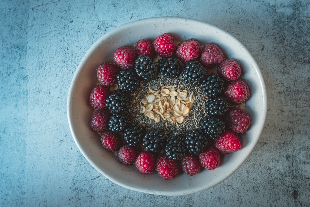 red and black berries on white ceramic bowl