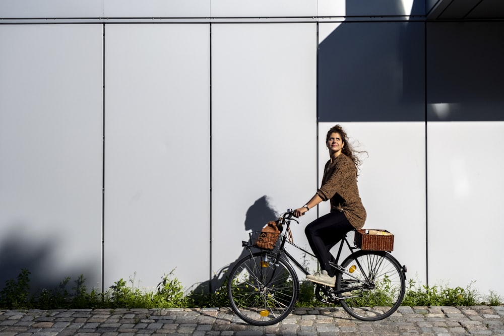 woman in brown dress riding on black city bike