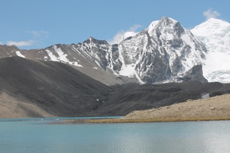 gray and white mountain near body of water during daytime