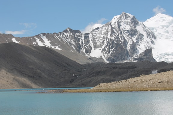 gray and white mountain near body of water during daytime