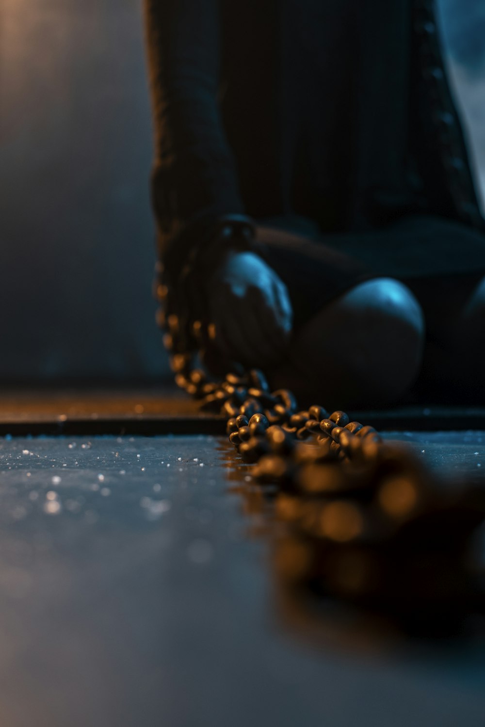 person holding blue stone on brown wooden table