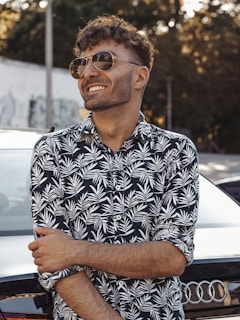 man in black and white floral button up shirt wearing black framed eyeglasses