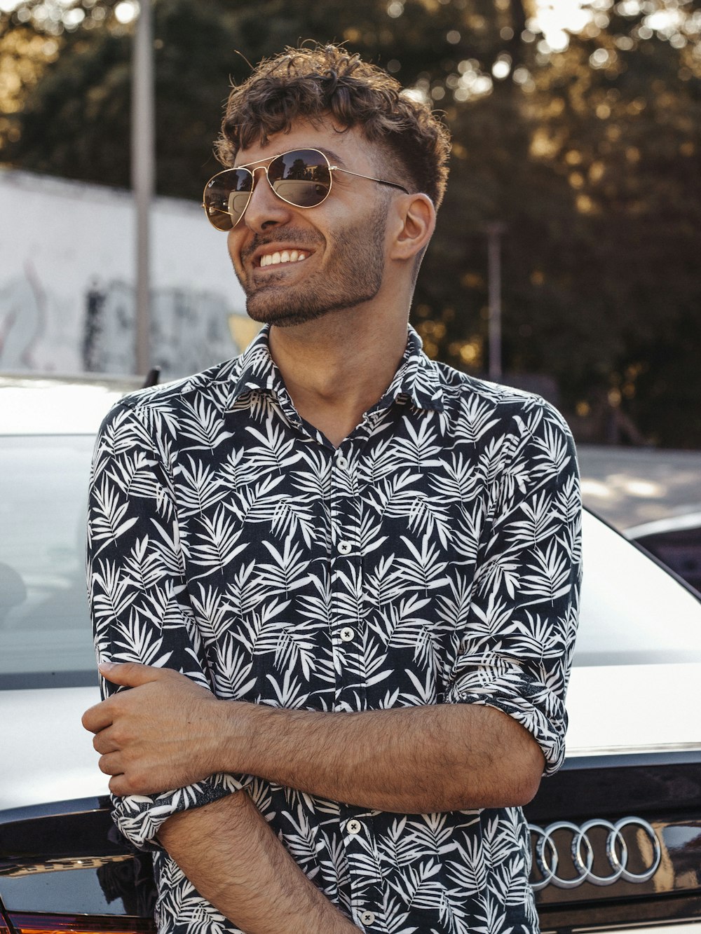 man in black and white floral button up shirt wearing black framed eyeglasses