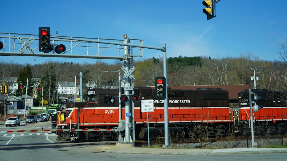Train rouge et noir sur les voies ferrées sous le ciel bleu pendant la journée