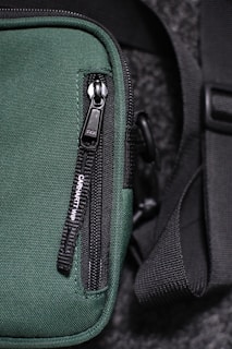 black and gray bag on green textile
