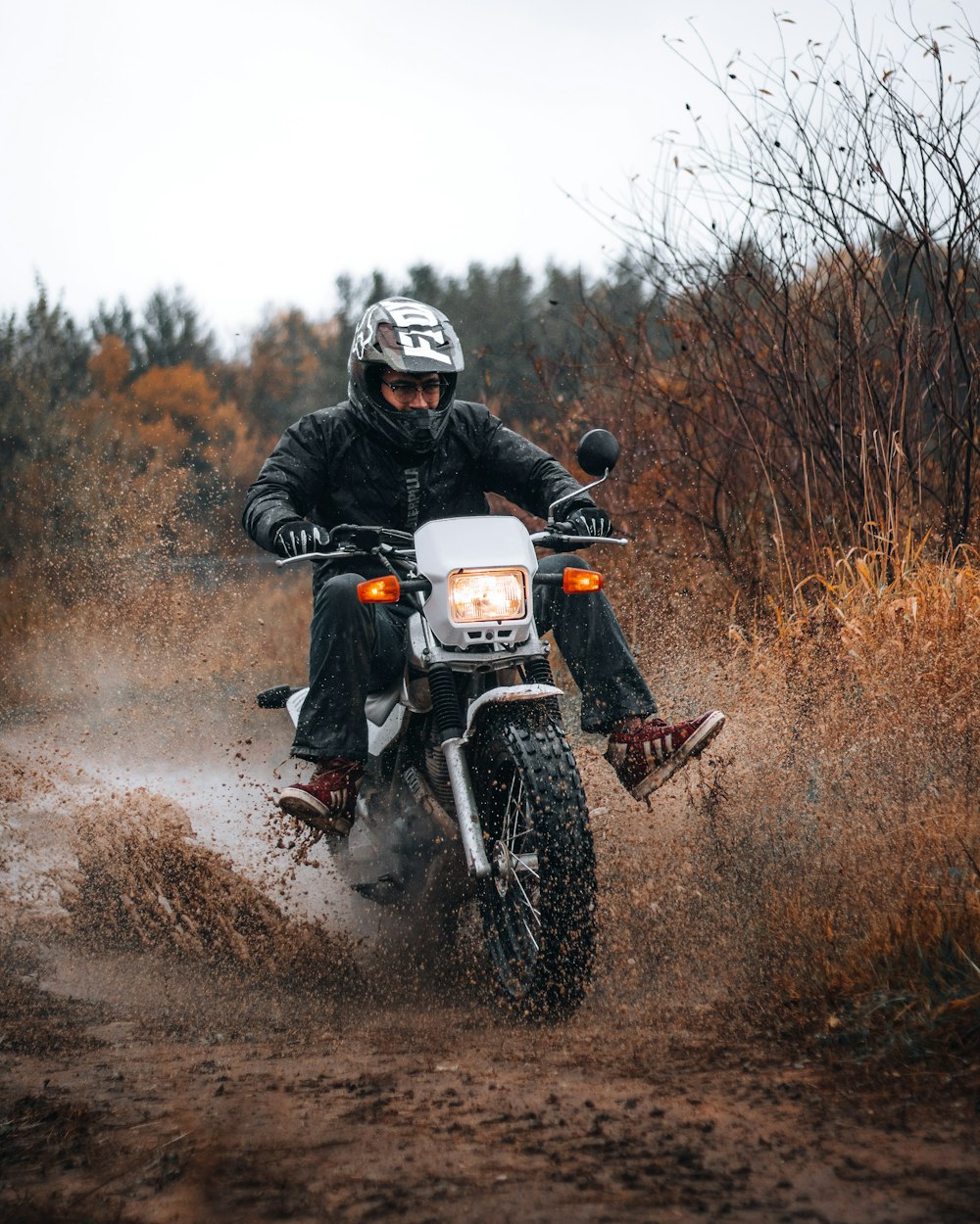 homme en casque de moto noir roulant sur une moto noire et blanche