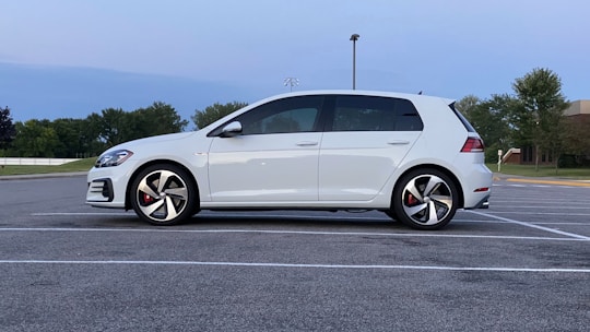 A learner driver practicing parking maneuvers in an empty parking lot.