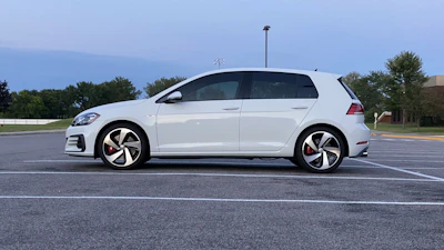 A single clean, drivable used car parked on an open lot under a clear sky.