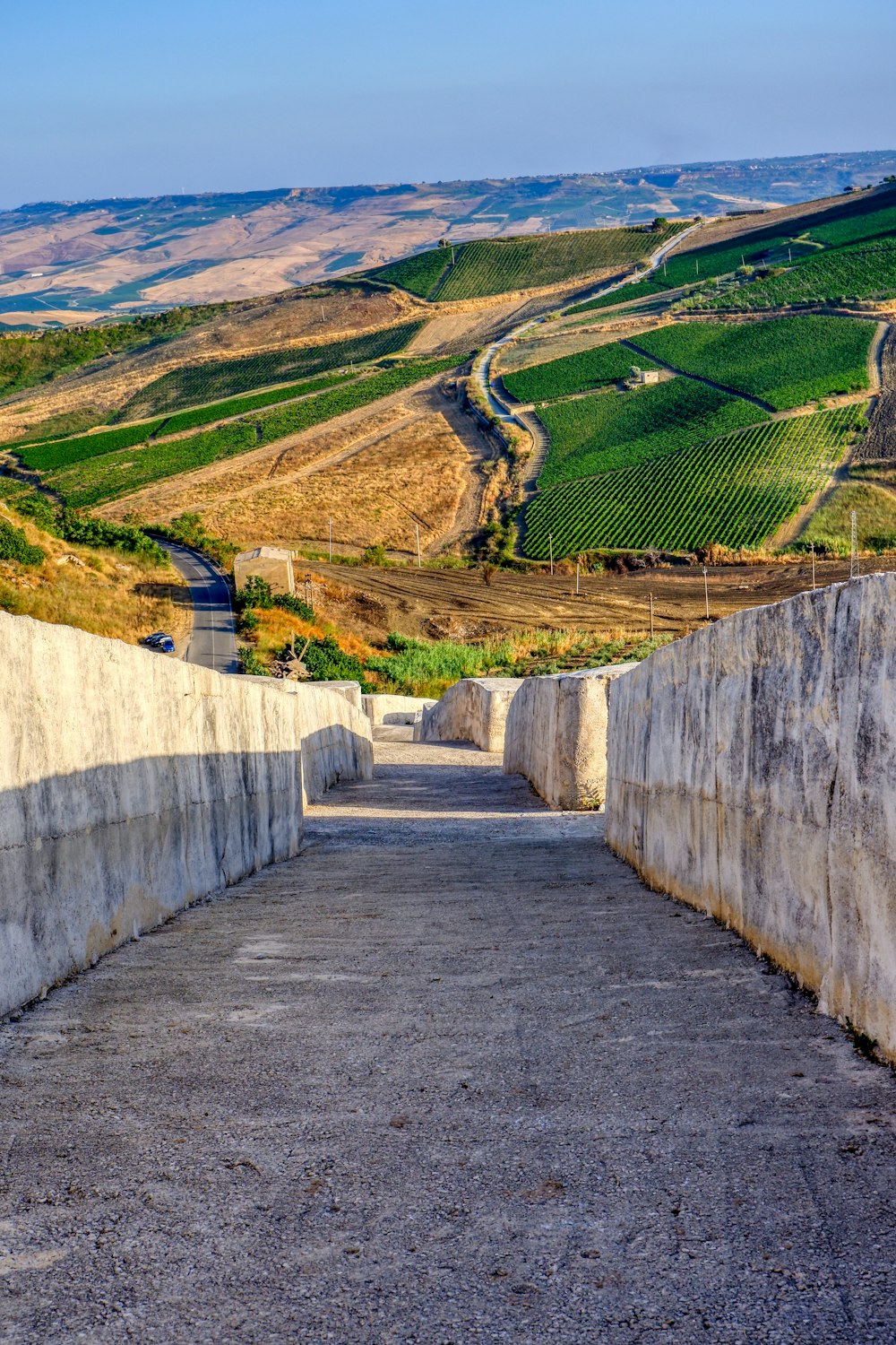 Graue Betonwand in der Nähe von grünem Grasfeld tagsüber