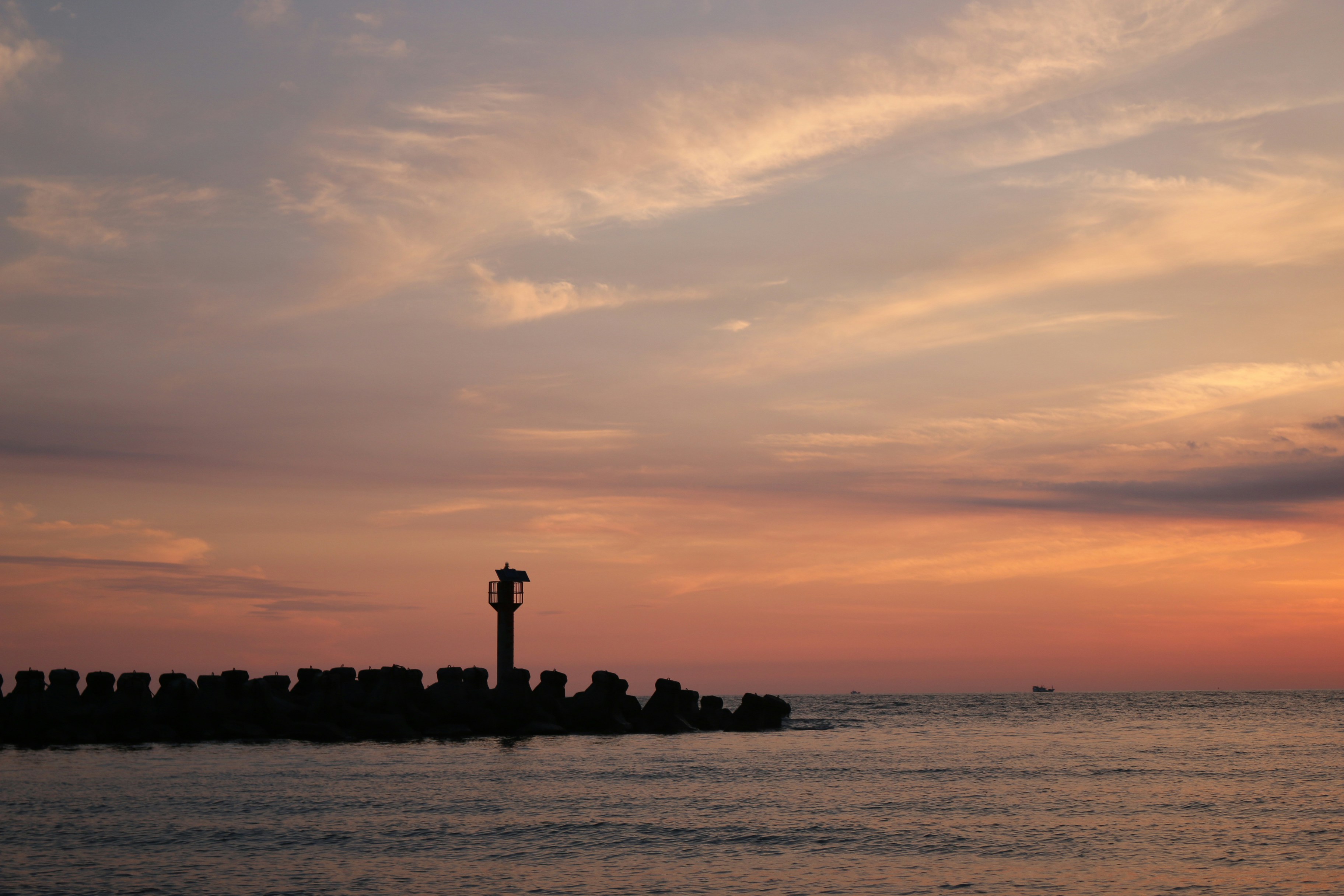 Sunset over the sea with coastal rocks