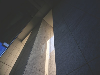 Sunlight casting sharp shadows on a minimalist concrete facade.