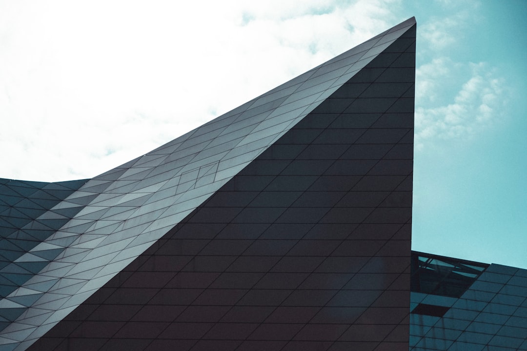 black and white concrete building under white clouds during daytime