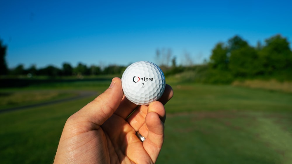 white golf ball on persons hand