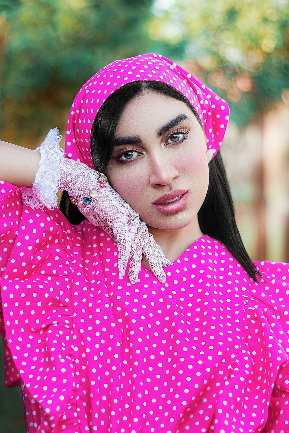 분홍색과 흰색 물방울 무늬 히잡을 쓴 여자