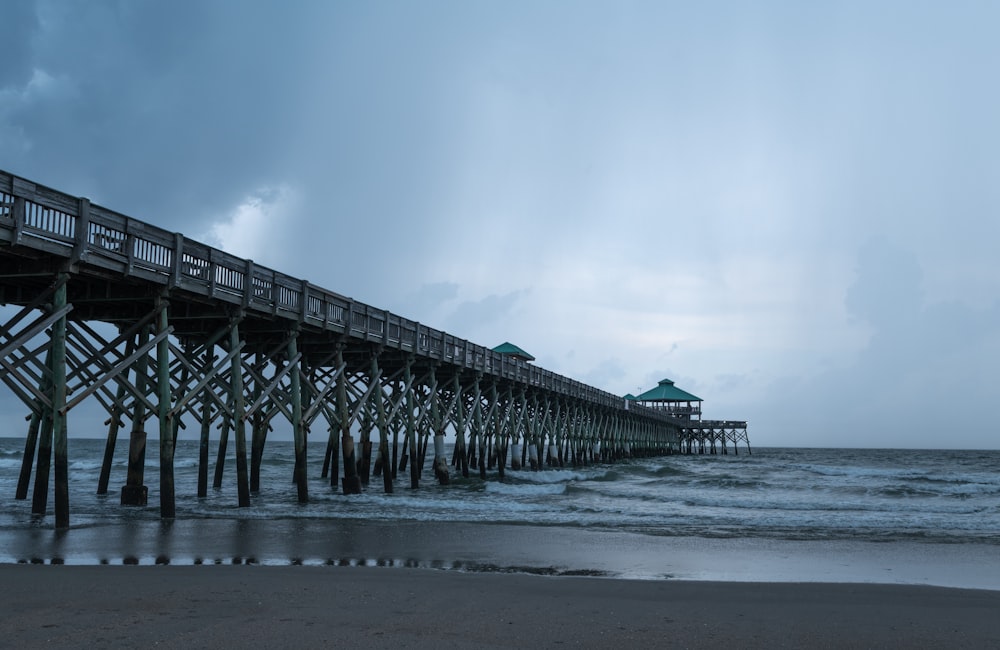 gray wooden dock on sea under gray sky