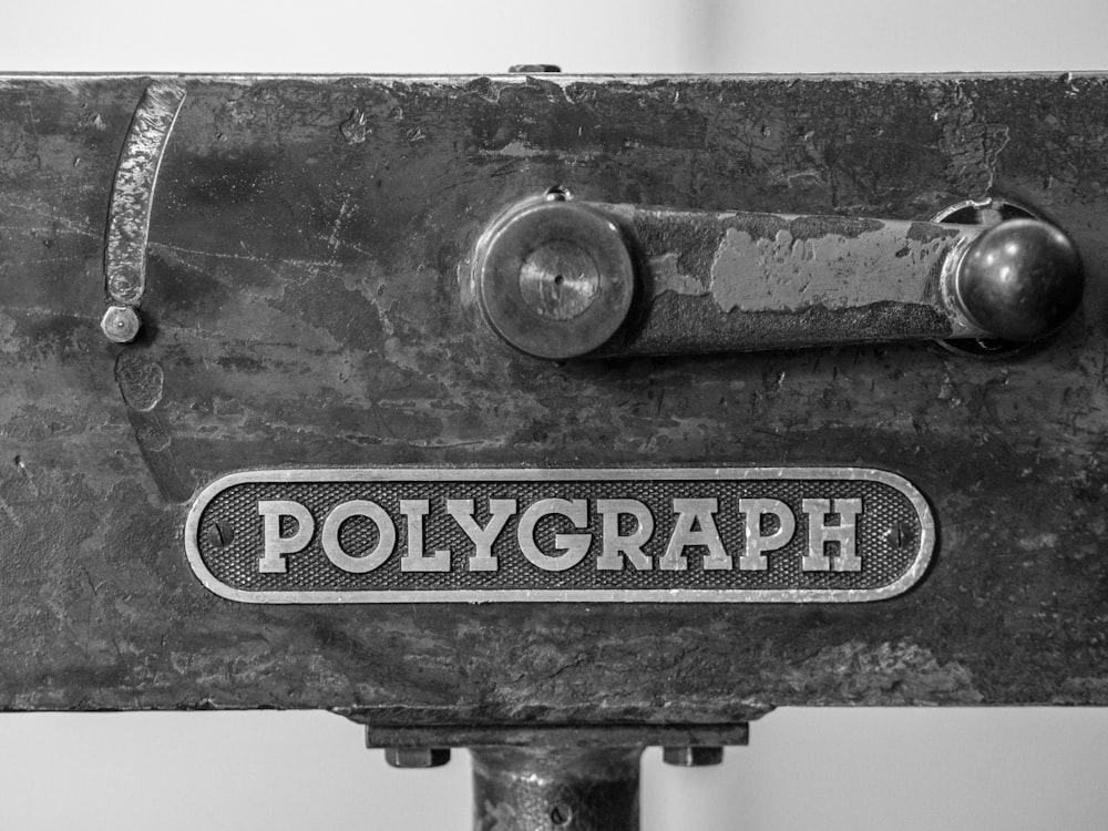 Una foto in bianco e nero di un oggetto metallico con la parola poligrafo su di esso