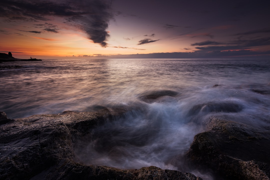 ocean waves crashing on rocks during sunset