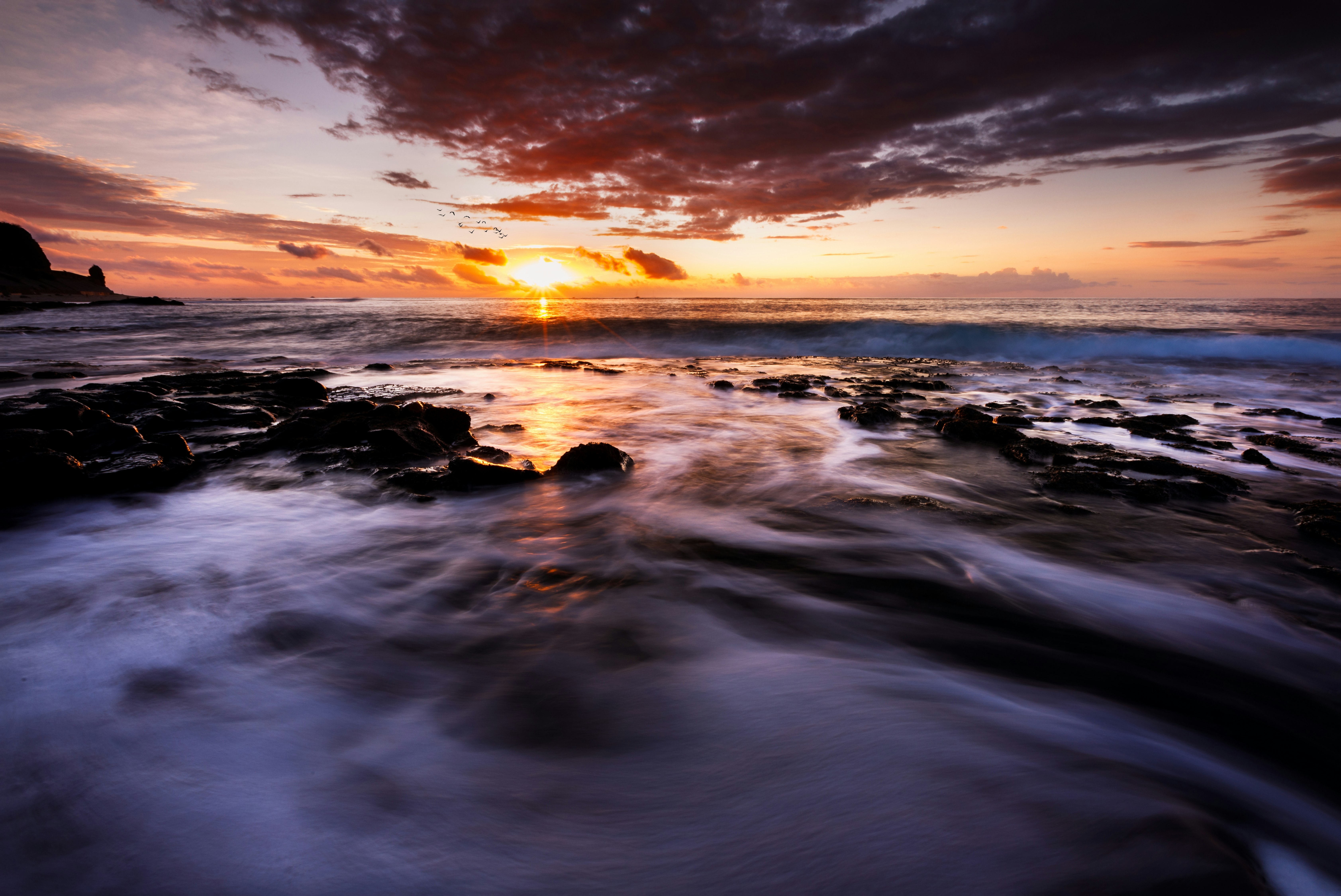 body of water under cloudy sky during sunset