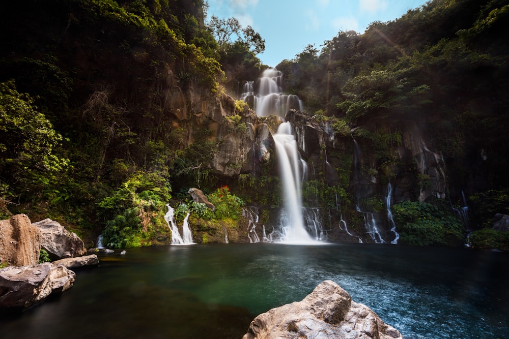 waterfalls in the middle of the forest during daytime