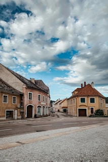 A charming European village street lined with colorful houses and blooming flowers under a bright sky.
