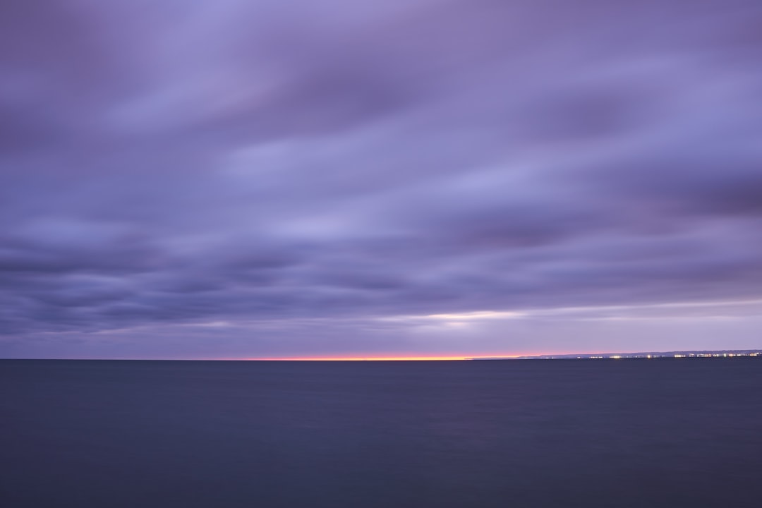 body of water under cloudy sky