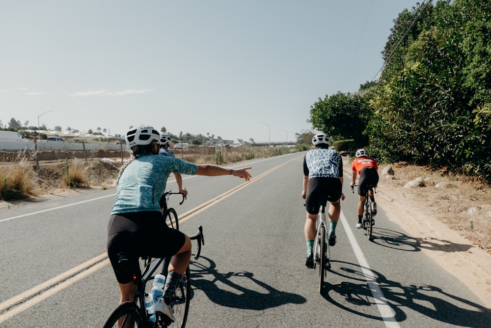 a group of people riding bikes down a road