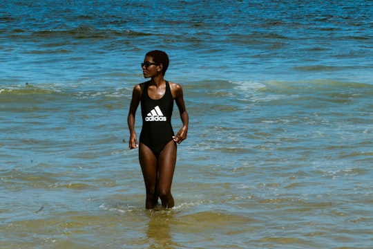 woman in black one piece swimsuit standing on sea water during daytime in Long Branch United States