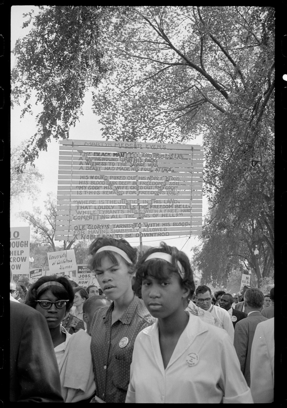 Young women with signs raised behind them at the March on Washington