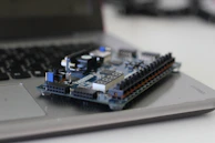 Close-up of a microcontroller board with blinking LEDs during prototyping.