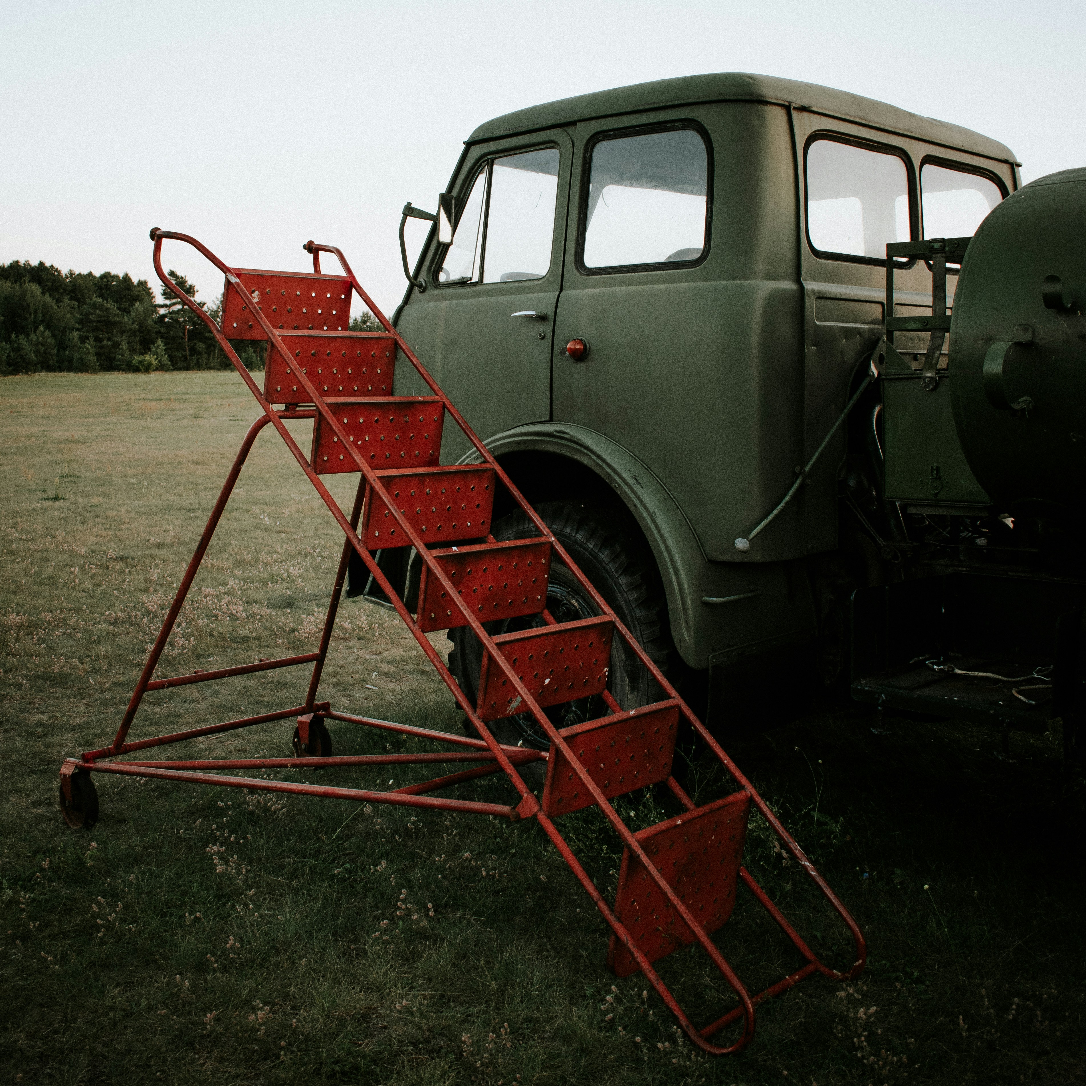 red and black utility trailer on brown field