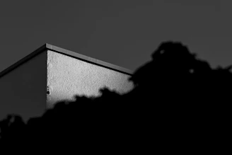 Architectural detail of a modern building’s corner, highlighting texture and shadow in a quiet luxury style.
