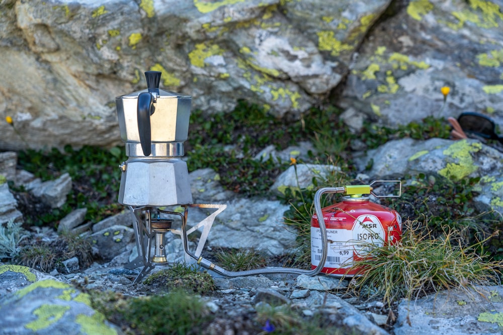 silver and black coffee maker on gray rock