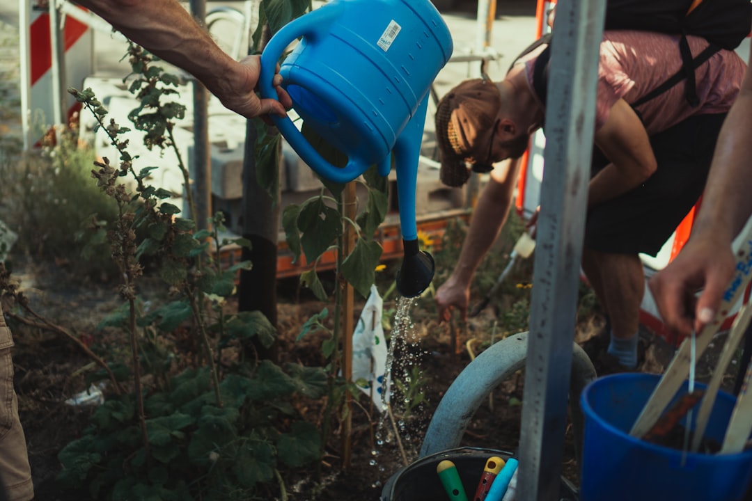 boy in blue tank top holding blue plastic bucket