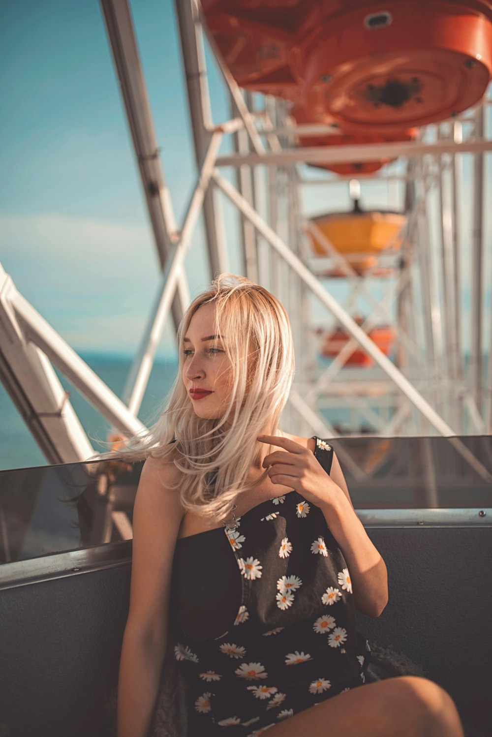 woman in black and white floral sleeveless dress standing on escalator