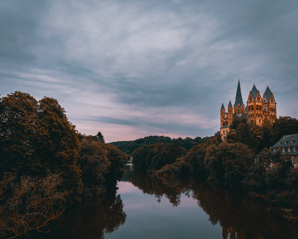 Serene castle stands majestically at dusk with warm orange light emanating from its windows