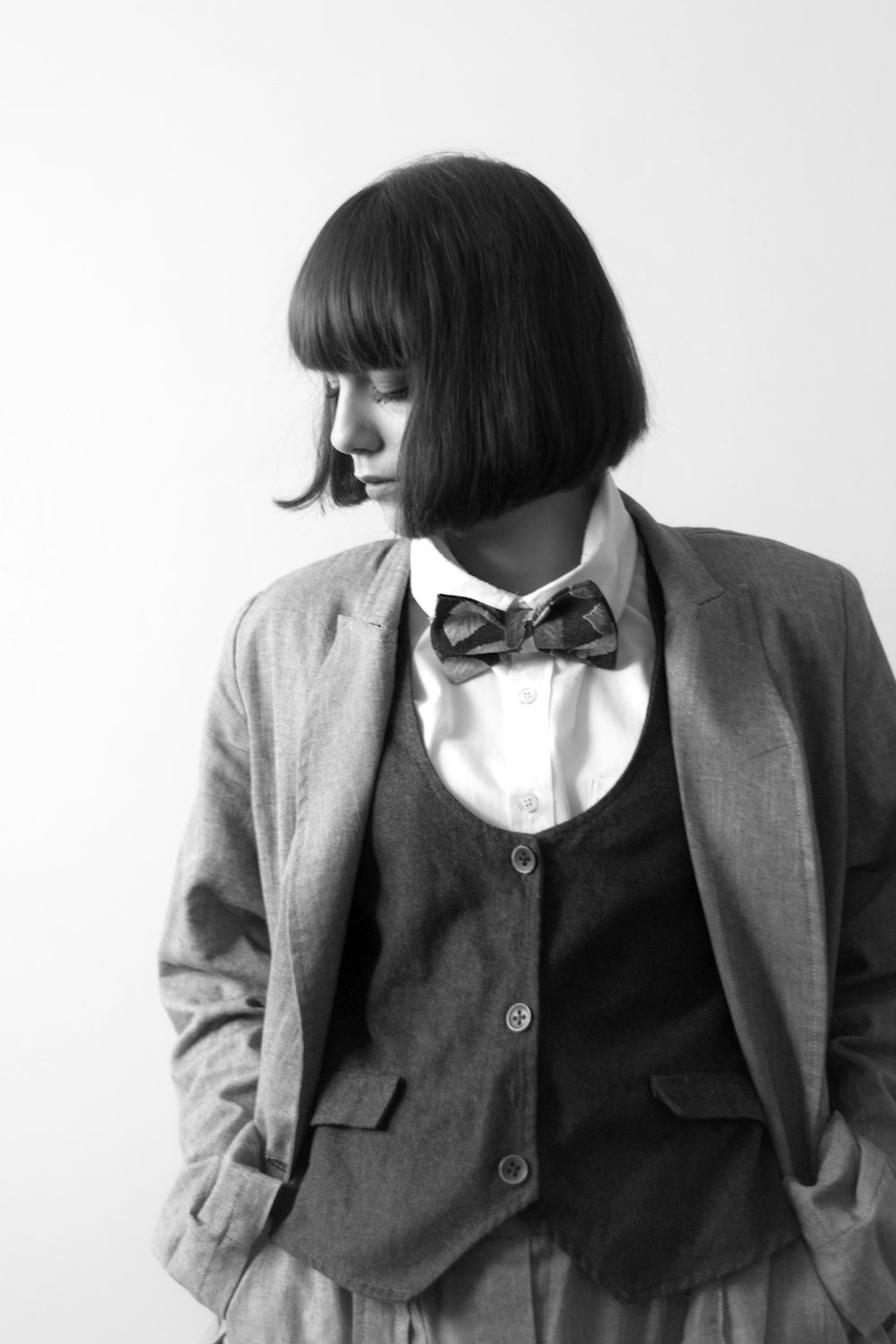 woman in gray blazer with black and white polka dots bowtie