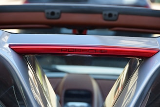 A sleek red Porsche 911 GT3 parked on the right side against a blurred black background.