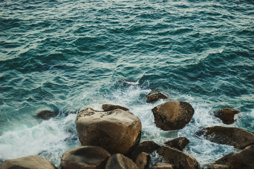 brown rocks near body of water during daytime