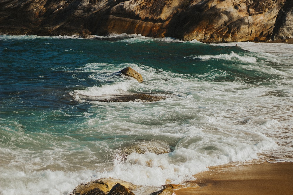 sea waves crashing on shore during daytime