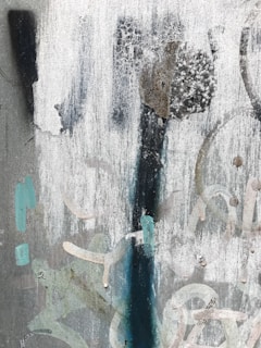 Abstract shot of urban textures—brick walls, peeling posters, and rain-soaked pavement in monochrome.