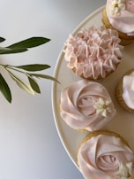 Cupcake with pastel pink icing and tiny hand-piped flowers perfect for a spring celebration.