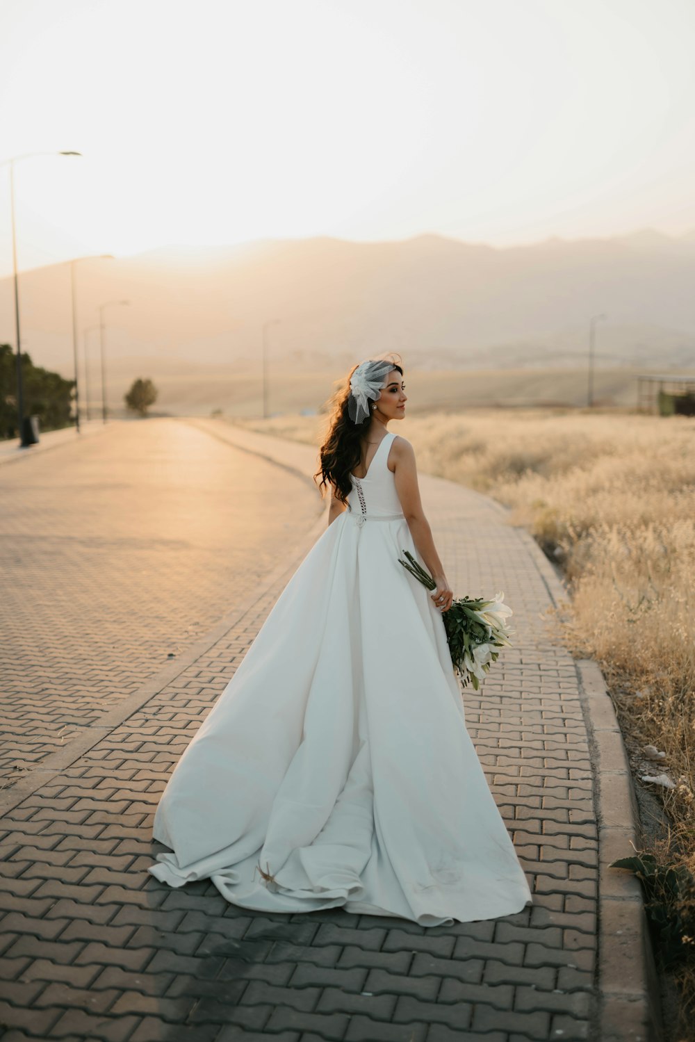 woman in white dress walking on road during daytime