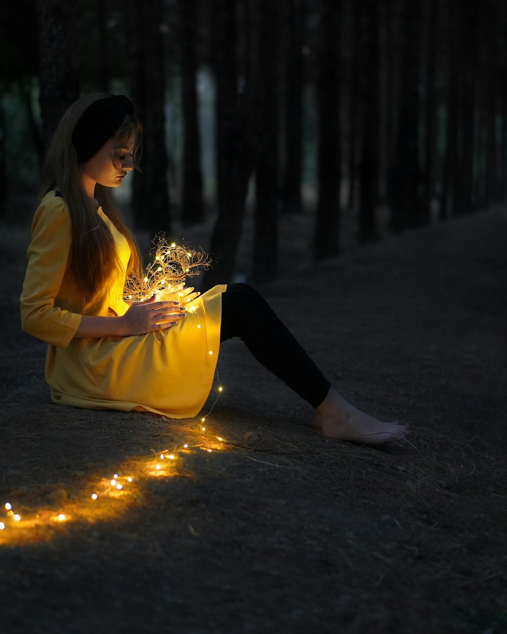 woman in yellow long sleeve shirt and black pants sitting on road during daytime