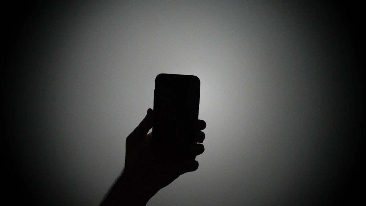 Siluet tangan memegang ponsel dengan lampu menyala