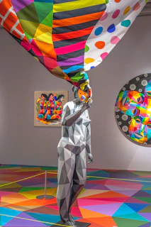 woman in white long sleeve shirt holding multi color balloons