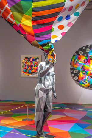 woman in white long sleeve shirt holding multi color balloons