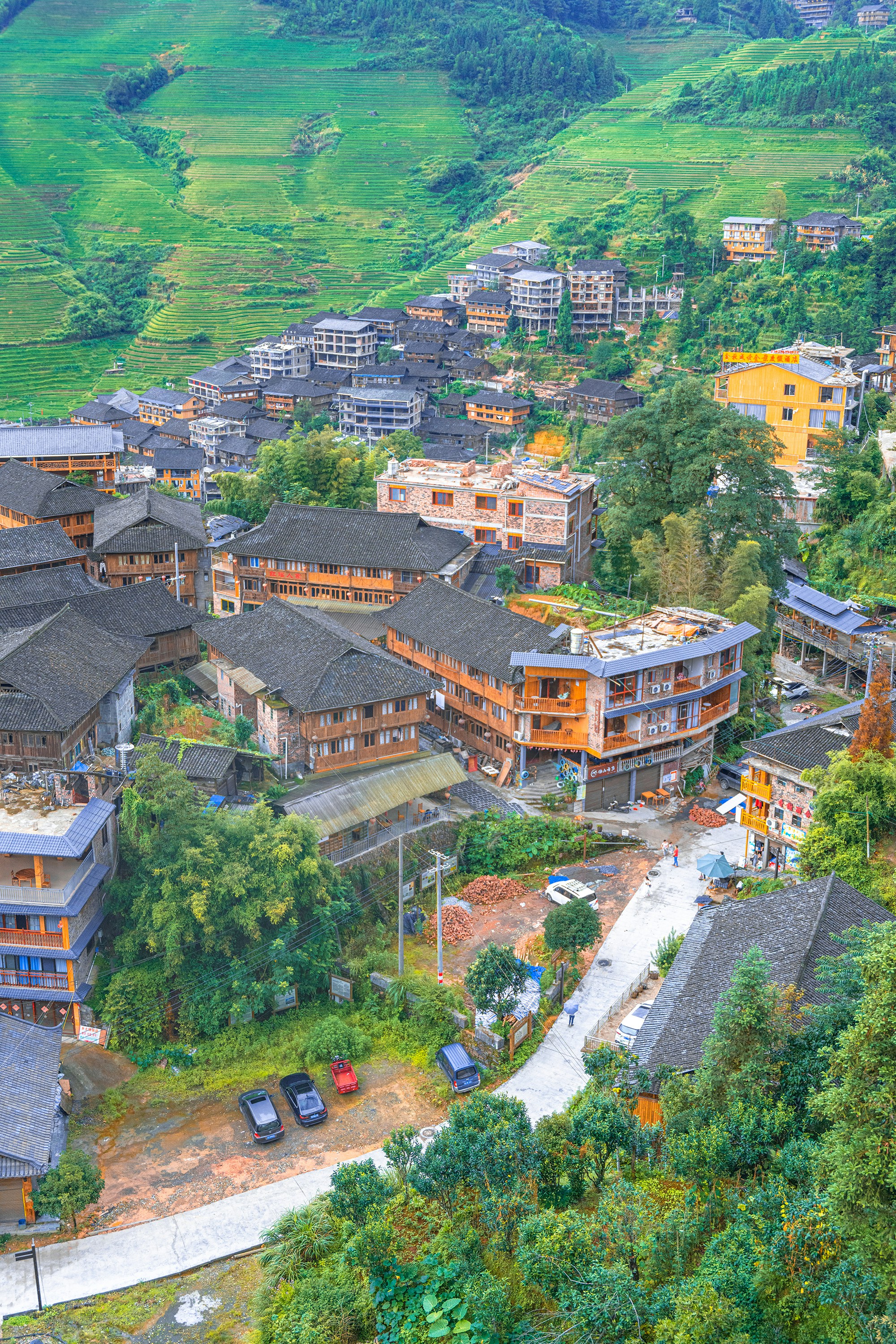 aerial view of brown and white concrete building surrounded by green trees during daytime