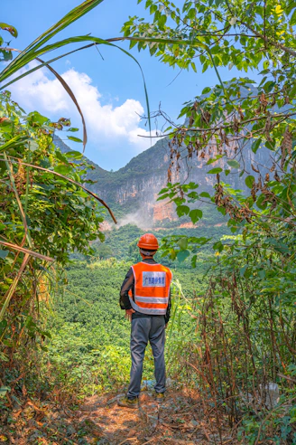 man in black jacket and black pants standing on green grass field during daytime